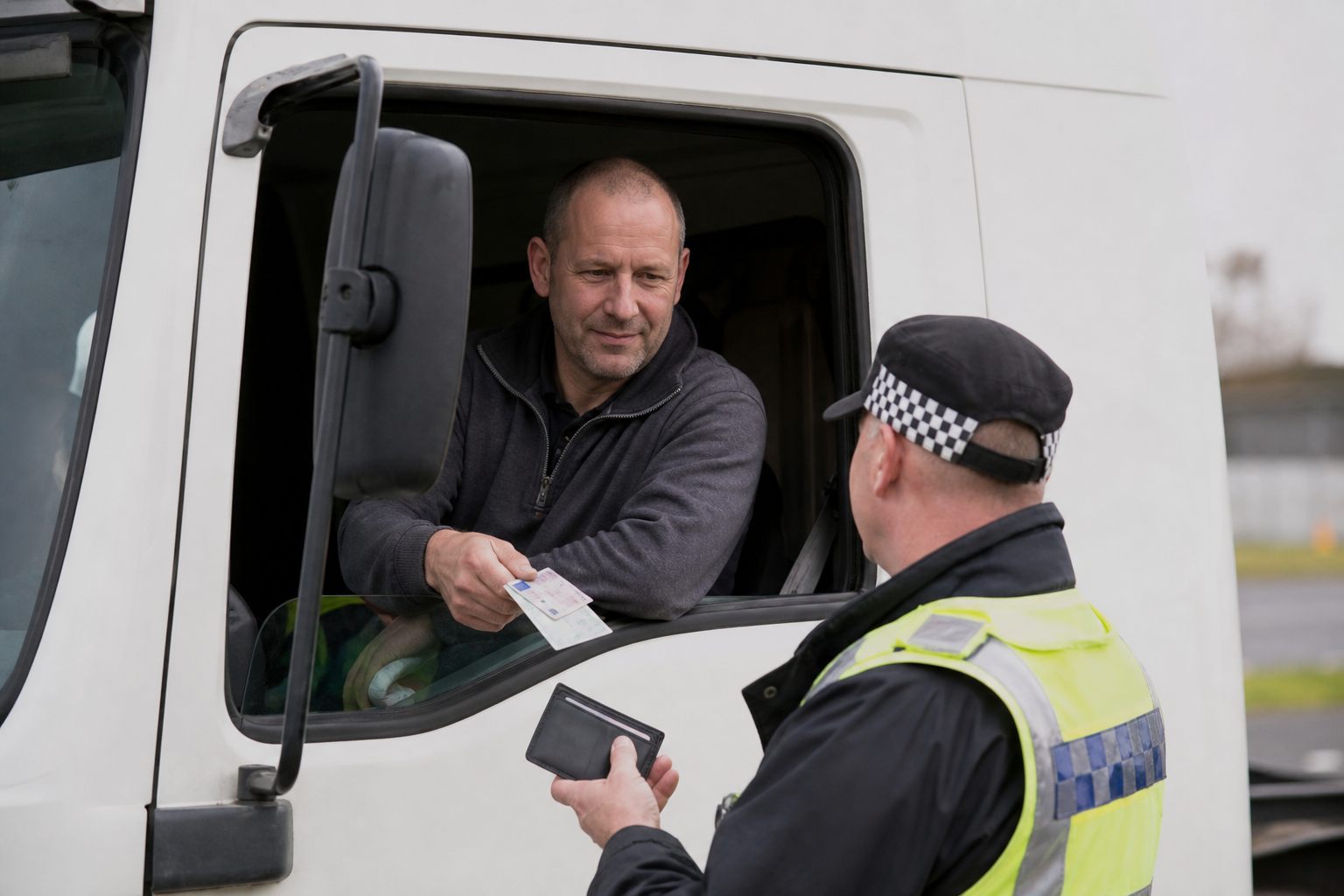 HGV driver presenting licence and cards at a UK roadside check